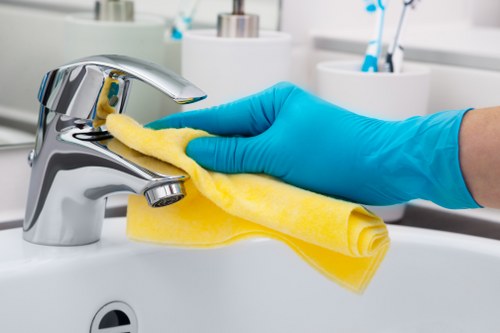 Cleaning kitchen cupboards and surfaces during a Wimbledon move-in service
